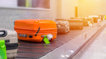 Kufferter, der ligger på et rullebånd i en lufthavn.