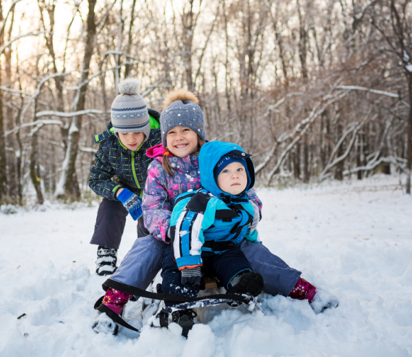 Tre børn der leger i sneen 