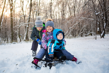 Tre børn der leger i sneen 